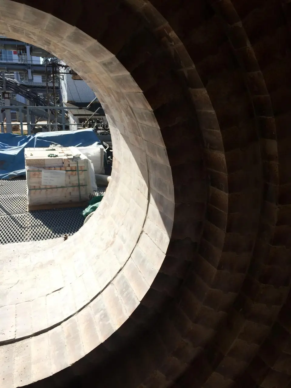 Refractory brick courses around a circular opening, seen from inside lined equipment